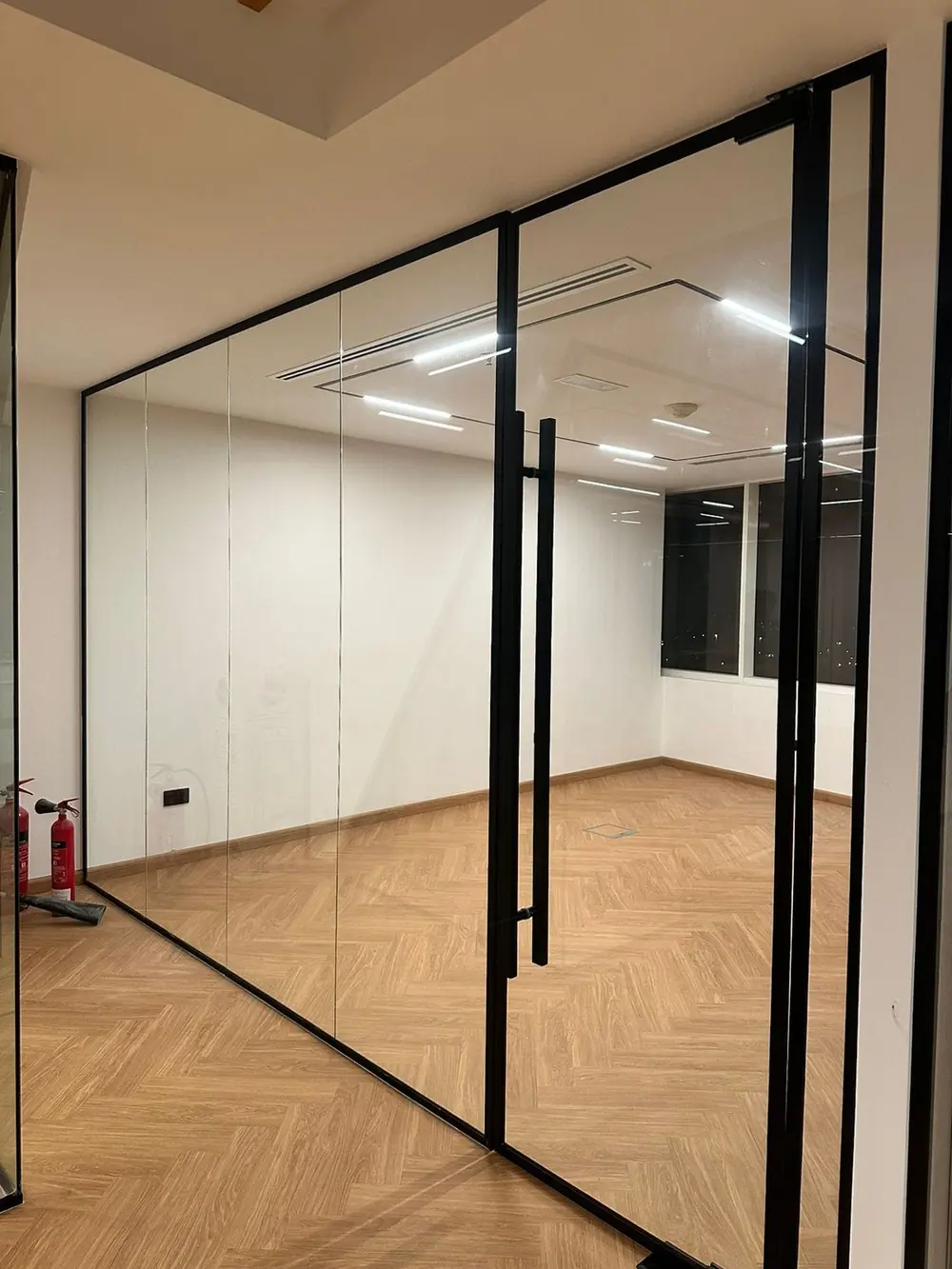 Completed office glass partition installation with black aluminum framing, Dubai