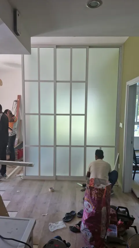 Framed privacy partition: White framing and frosted panels define an enclosed space. This photograph records installation work.